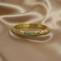 Goudkleurige bangle armband met turquoise en beige bloemen